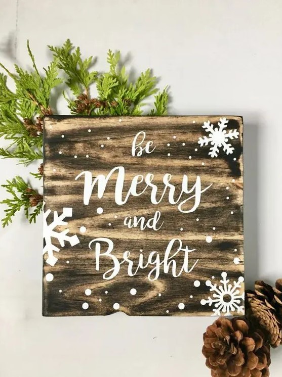 a snowy Christmas sign decorated with evergreens is an easy and very cozy holiday craft