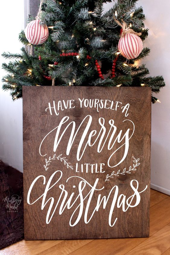 a stained plywood Christmas sign with white calligraphy will fit many decor styles and themes, especially rustic and farmhouse ones