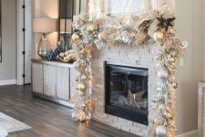a super glam Christmas mantel garland of white and gold ornaments, white and gold leaves and grasses plus lights