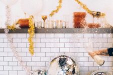 a vintage bathtub filled with disco balls and gold tinsel garlands used for NYE decor are amazing
