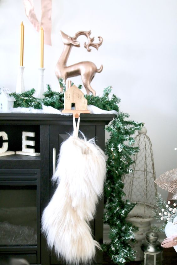 a white faux fur Christmas stocking is a pretty statement idea for a modern Christmas space, it looks textural and catchy