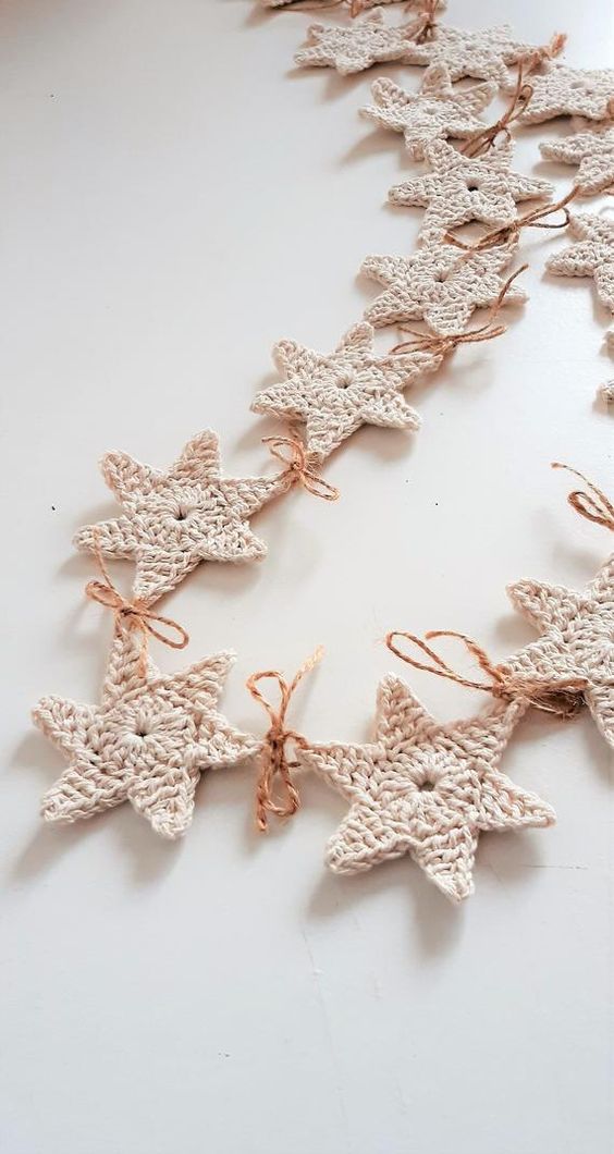 a white knit star garland with twine is a pretty idea to style a Christmas tree, a mantel, a window or you may use them as gift tags