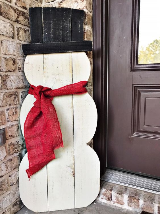 a white plywood snowman with a top hat and a red burlap scarf is a cool and bold idea for styling your outdoor space, you can DIY it