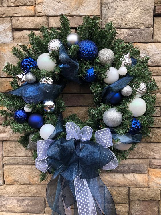 an elegant Christmas wreath with white, silver, navy ornaments, white and navy ribbon bows and ribbons is amazing