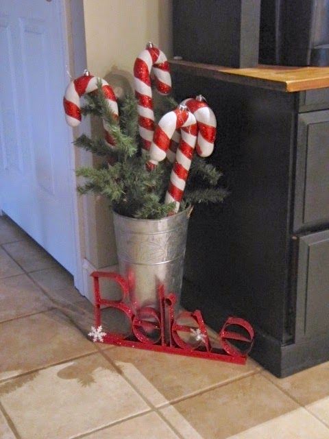 classy Christmas decor with a bucket with fir branches, candy canes and letters is gorgeous and whimsical