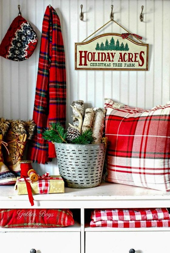 decorate your entryway with a plaid scarf, plaid pillows, blankets and gift boxes, add branches and pinecones to give the space a holiday feel at once