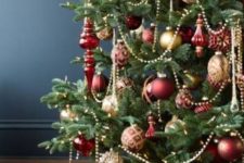 elegant red and gold Christmas tree decor with beads, ornaments, lights and gift boxes