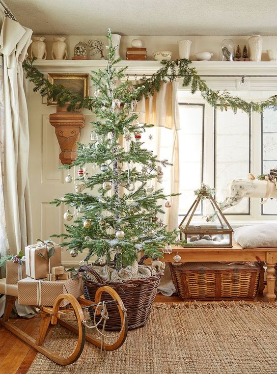 farmhouse Christmas styling with baskets, a wooden sleigh with gifts, an evergreen garland, pillar candles and vases