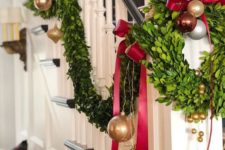 gold, red and brown ornaments, evergreens and deep red bows for decorating the railing