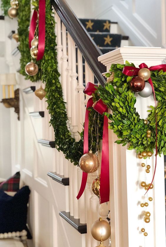 gold, red and brown ornaments, evergreens and deep red bows for decorating the railing