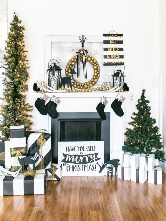 gorgeous glam Christmas decor with gold ornaments, black stockings, striped black and white gifts and lights is chic