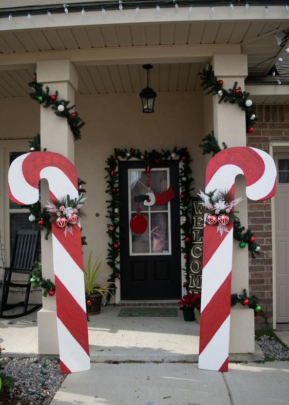 oversized candy canes with ornaments and fir branches will make your home entrance and make it look bold and cool