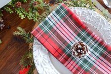 plaid napkins, red ribbons, evergreens and snowy pinecones will make up a gorgeous Christmas table
