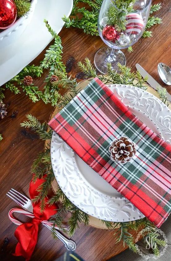 plaid napkins, red ribbons, evergreens and snowy pinecones will make up a gorgeous Christmas table