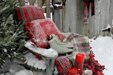 pretty outdoor plaid decor with pillows, blankets and a chest done in plaid, with skates, antlers and faux berries is amazing