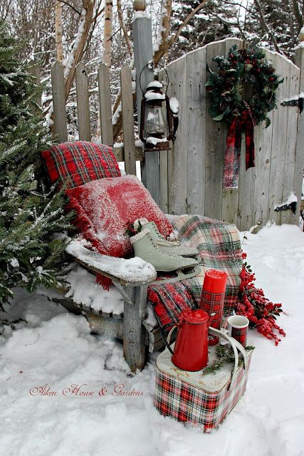 pretty outdoor plaid decor with pillows, blankets and a chest done in plaid, with skates, antlers and faux berries is amazing