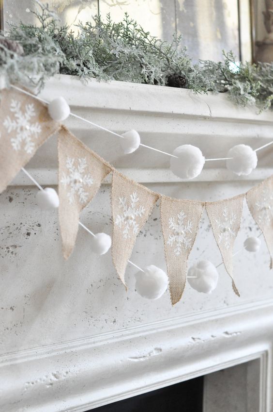 snowy Christmas mantel decor with a burlap runner, snowball garlands and snowy greenery is very chic and elegant