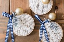 white braided knit ornaments with embroidery hoops, plaid ribbons, evergreens and gold ornaments are a great wya to upcycle an old sweater