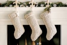 white knit stockings attached to a mantel will instantly make it feel like Christmas and you may personalize each of them
