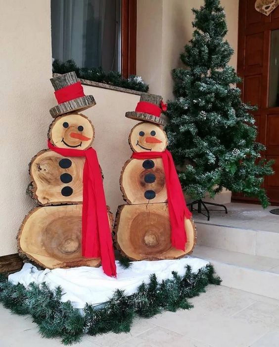 wood slice snowmen in wood slice hats, with faux snow and evergreens, red scarves are fantastic for rustic Christmas decor