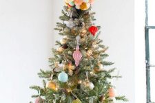 a colorful pompom Christmas tree topper matches the colorful decor fo the tree and adds fun to the decor