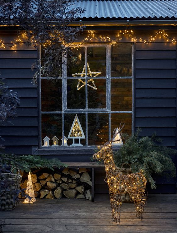 a light garland under the roof, a vine and light deer figurine, a lit up vine cone Christmas tree for natural and pretty outdoor holiday styling