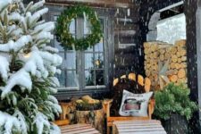 a little winter terrace with wooden loungers, a tree stump table, firewood, Christmas trees and a wreath
