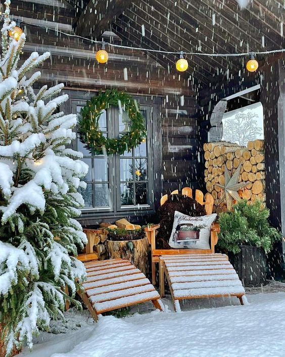 a little winter terrace with wooden loungers, a tree stump table, firewood, Christmas trees and a wreath