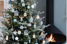 a pretty Christmas tree with lights, white, aqua and navy ornaments, mini house ornaments and a matching topper for a bold look