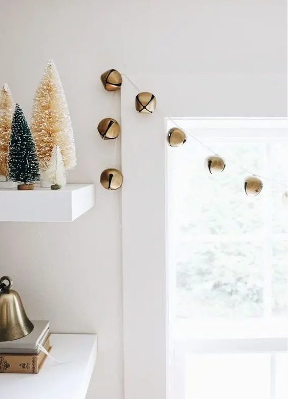a simple garland of gold Christmas bells is a lovely and chic idea that will easily bring festive spirit to the space