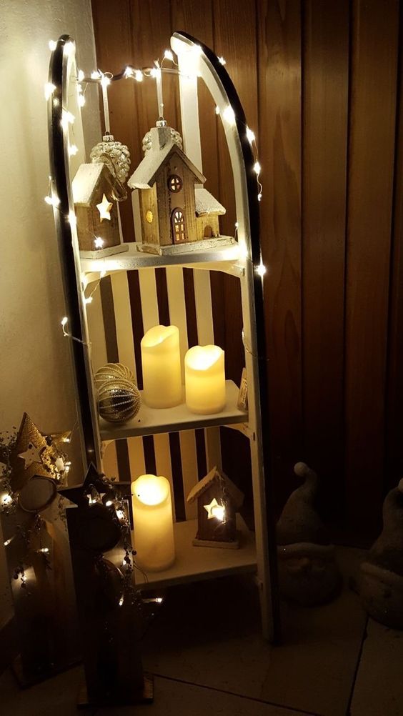a vintage sleigh with wooden houses, lights, pillar candles and oversized Christmas ornaments is a great Christmas decoration for both indoors and outdoors