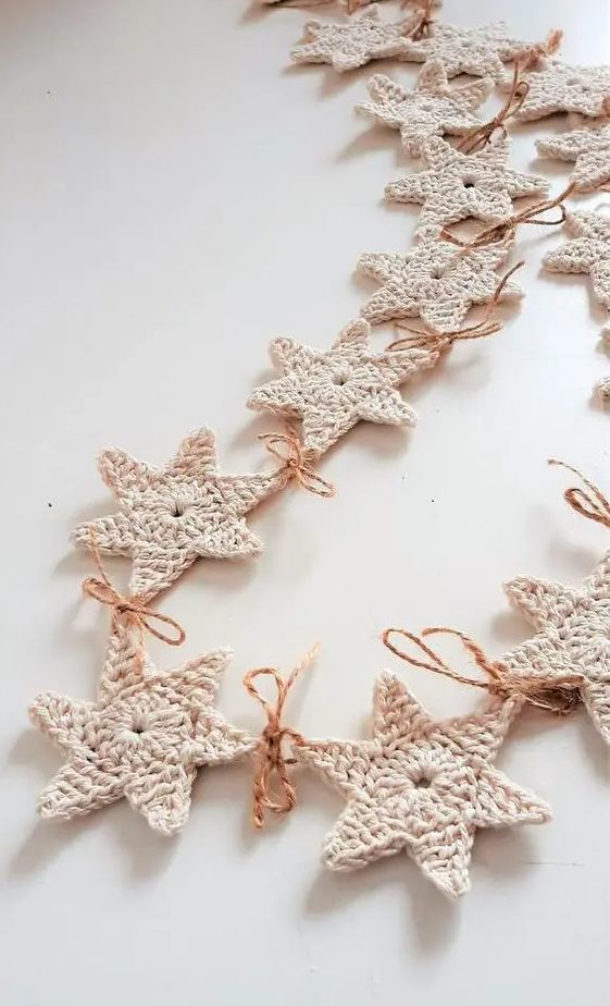a white knit star garland with twine is a pretty idea to style a Christmas tree, a mantel, a window or you may use them as gift tags