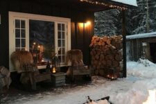 a winter terrace with a wooden chairs covered with faux fur, candle lanterns, a stack of firewood, a fire bowl is awesome