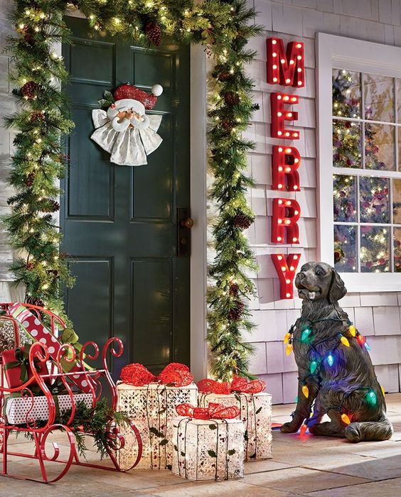 an evergreen, pinecone and light garland, red marquee letters, a dog figurine wrapped with vintage lights