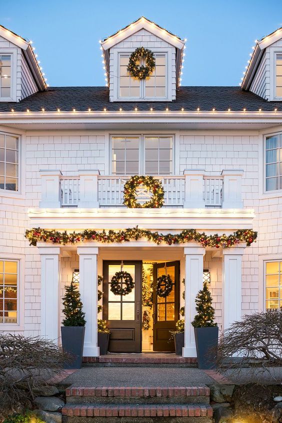 evergreen and light wreaths and garlands, mini Christmas trees with lights and topiaries are right what you need to style the exterior of your house