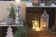 pretty winter balcony decor with crates, candle lanterns, moss and evergreens, deer and plywood trees