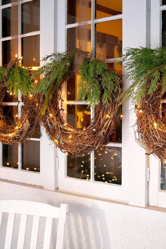 vine wreaths with lights and evergreens hanging on your windows or doors outdoors make the outdoor spaces very Christmassy