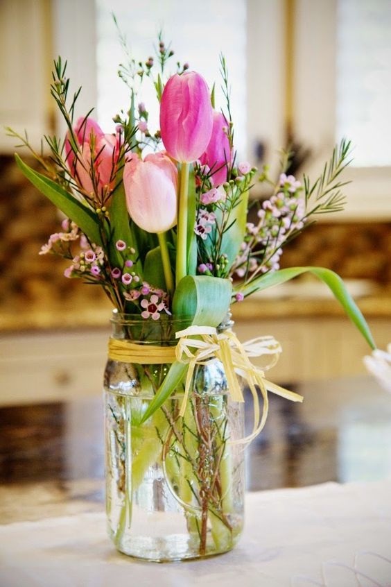 a beautiful Easter flower arrangement with pink tulips and other blooms plus greenery is a simple and cool rustic idea