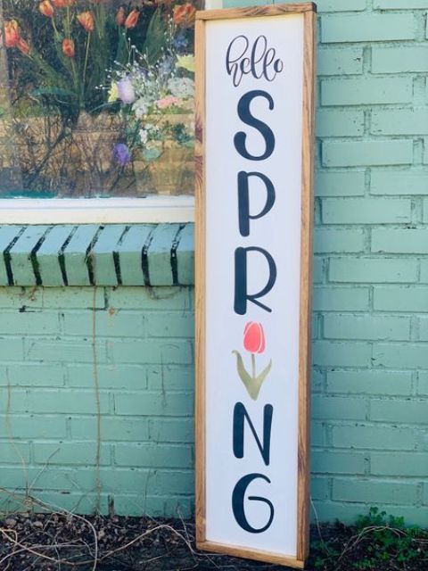a bright and simple spring sign with black letters, a tulip and a light stained wooden frame is chic