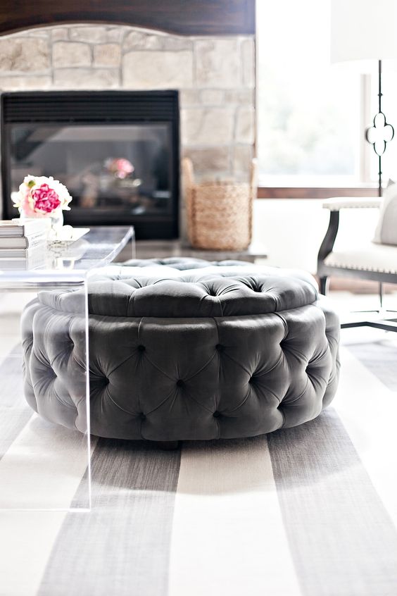 a large round tufted ottoman can be placed under the coffee table and you can store stuff inside it