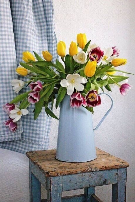 a metal jug with yellow, pink and white tulips is a bold and pretty spring arrangement idea