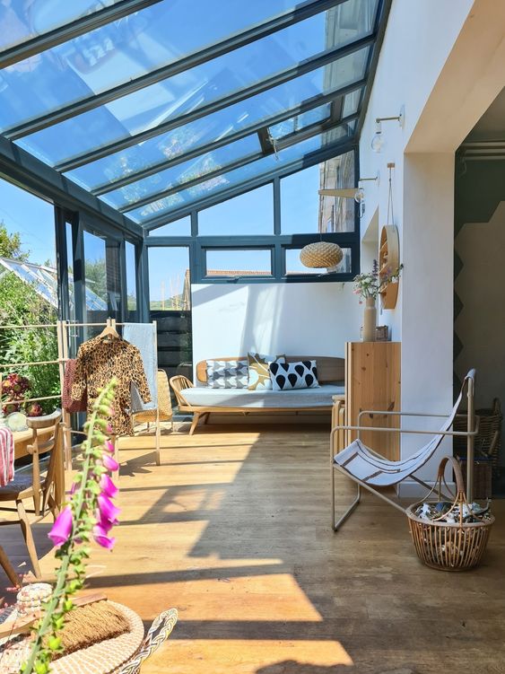 a mid-century modern sunroom with plywood and metal furniture, printed textiles and a dining space in the sun