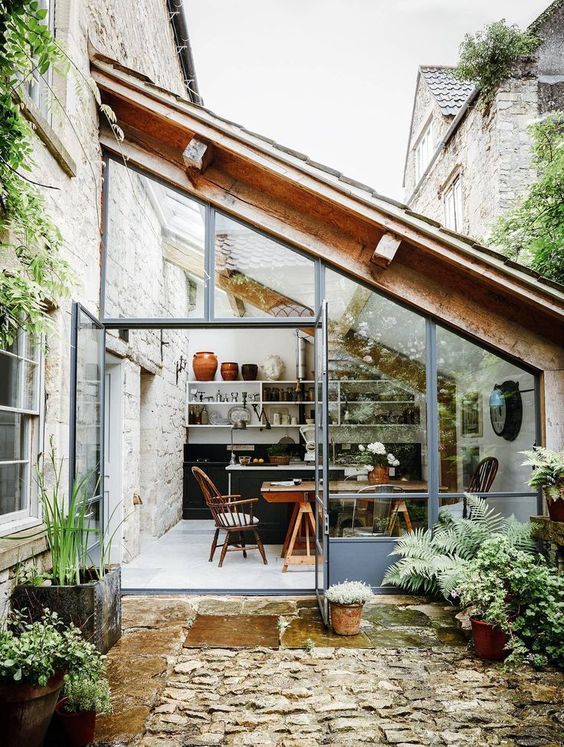 a modern kitchen and dining space designed as a sunroom are great for cooking and having meals feeling almost outdoors