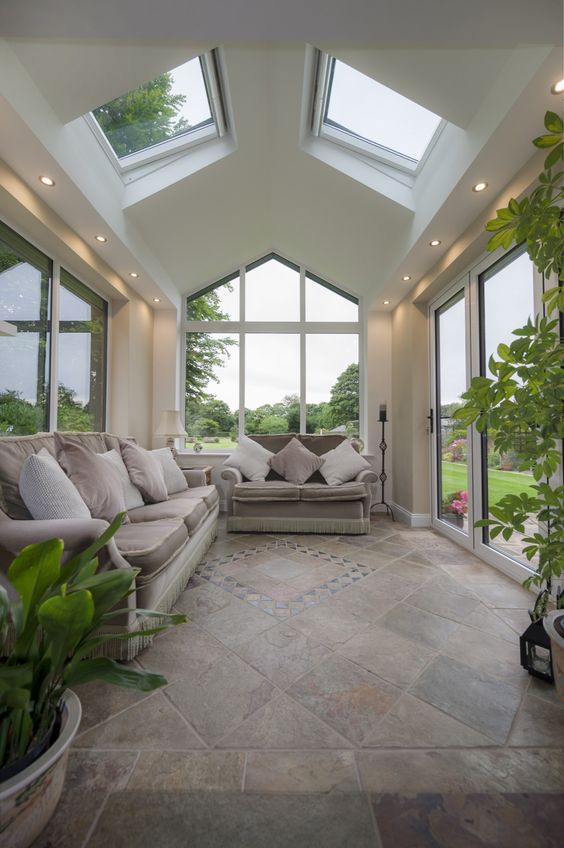 a stylish modern sunroom with elegant sofas, potted greenery and nice views is welcoming