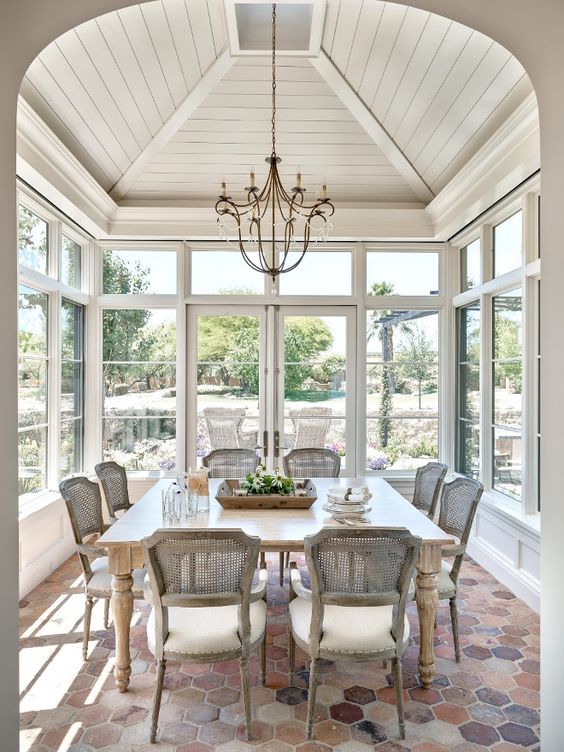 an elegant shabby chic sunroom dining space with stylish rattan chairs and a large table is great