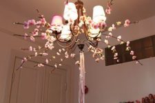 decorate your chandelier with silk blooming branches and ribbons to make it feel like spring