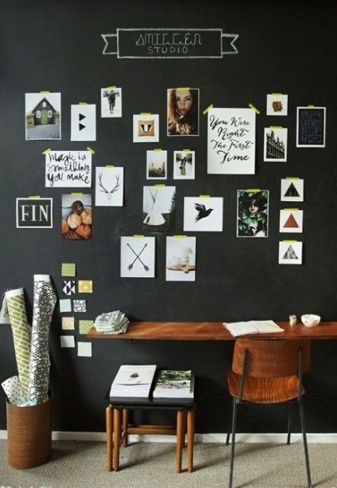 a stylish farmhouse living room with a chalkboard wall, a gallery wall and simple stained furniture