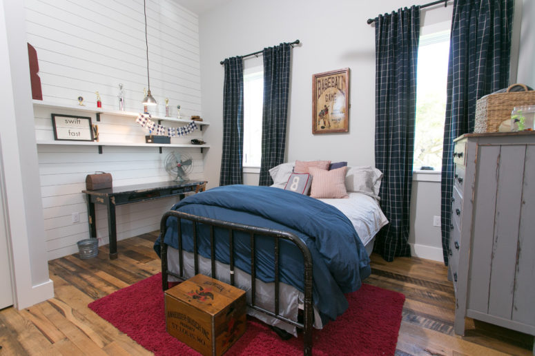 a farmhouse boy's bedroom in navy, red and white, with printed textiles, a crate, a sideboard and a vintage desk  (Meredith Owen Interiors)