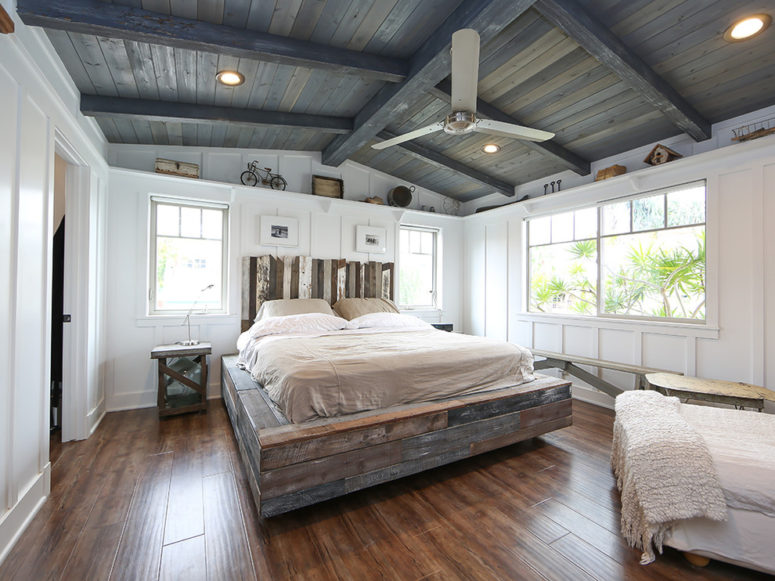 a farmhouse bedroom with white walls, a weathered wood ceiling, a weathered wood platform bed and a barnwood headboard  (Better Living SoCal)