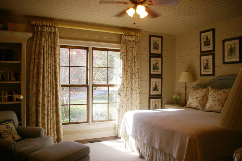 a vintage farmhouse bedroom in neutrals, with printed textiles and many artworks  (Architectural Designs)